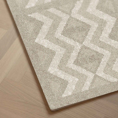Close-up of Eeveve Kilim Play Mat - Dark Taupe on a wooden floor.