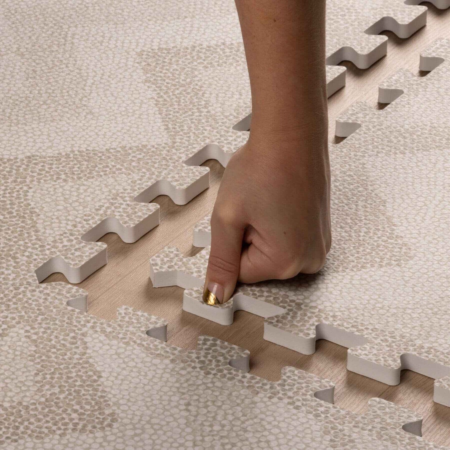 Hand placing on Eeveve Kilim Play Mat, Feather Gray