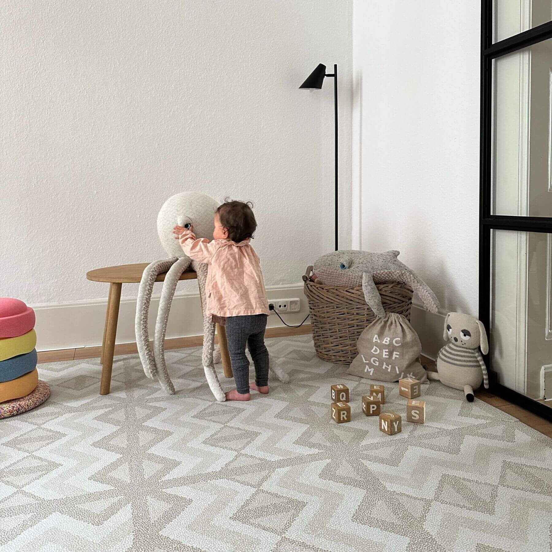 Child playing with toys in a room with Eeveve Kilim Play Mat, Feather Gray
