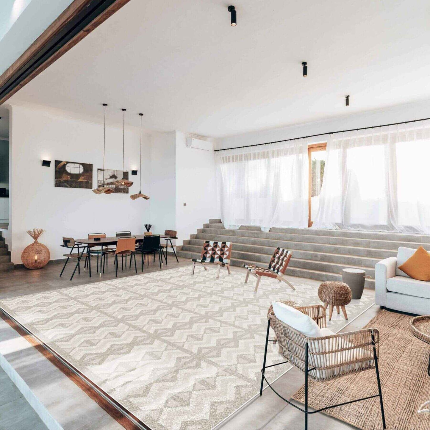Modern living room with Eeveve Kilim Play Mat - Feather Gray, white sofa, and decorative chairs.