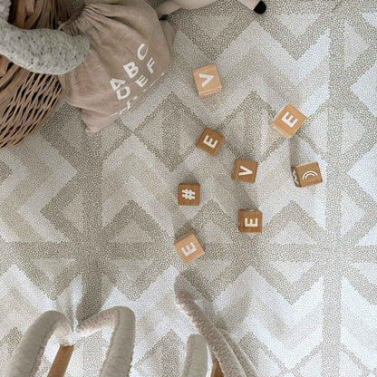 Wooden blocks with letters on Eeveve Kilim Play Mat, Feather Gray