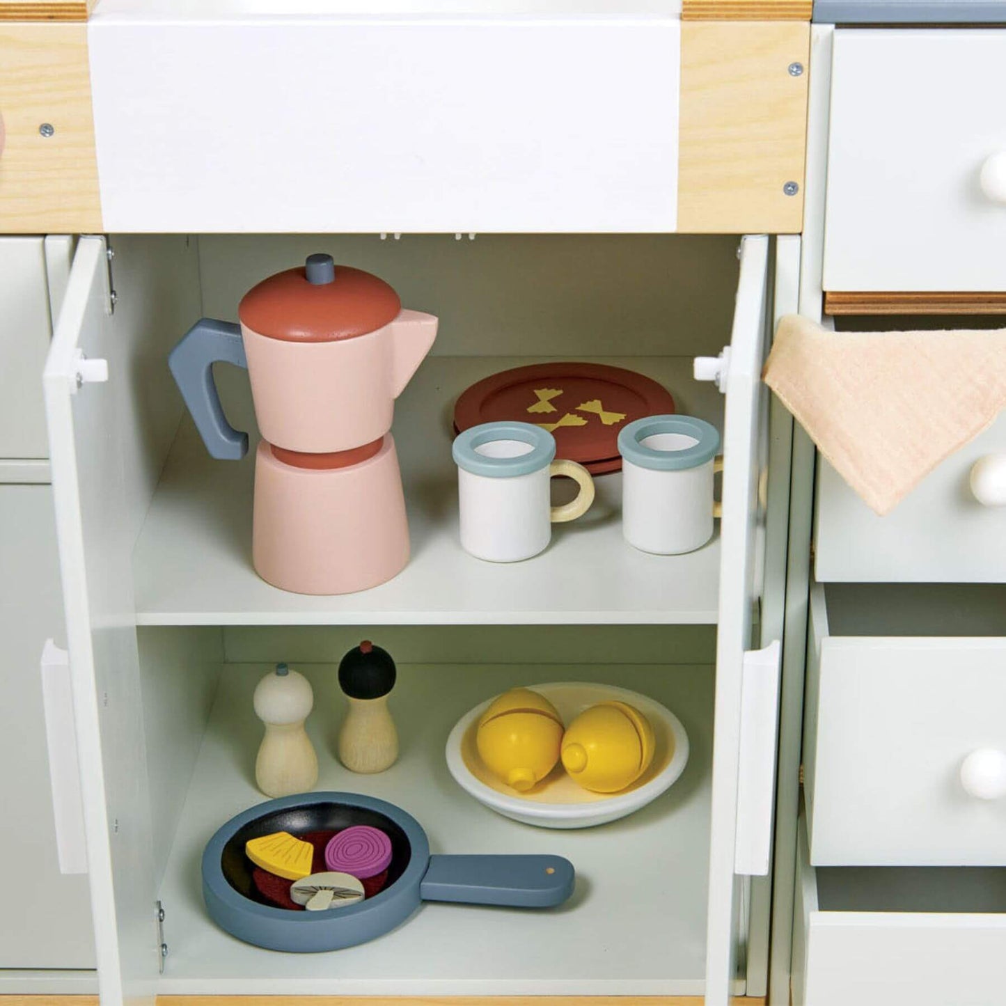 Children's kitchen playset with toys including a pink coffee maker, cups, lemons, and a pan.