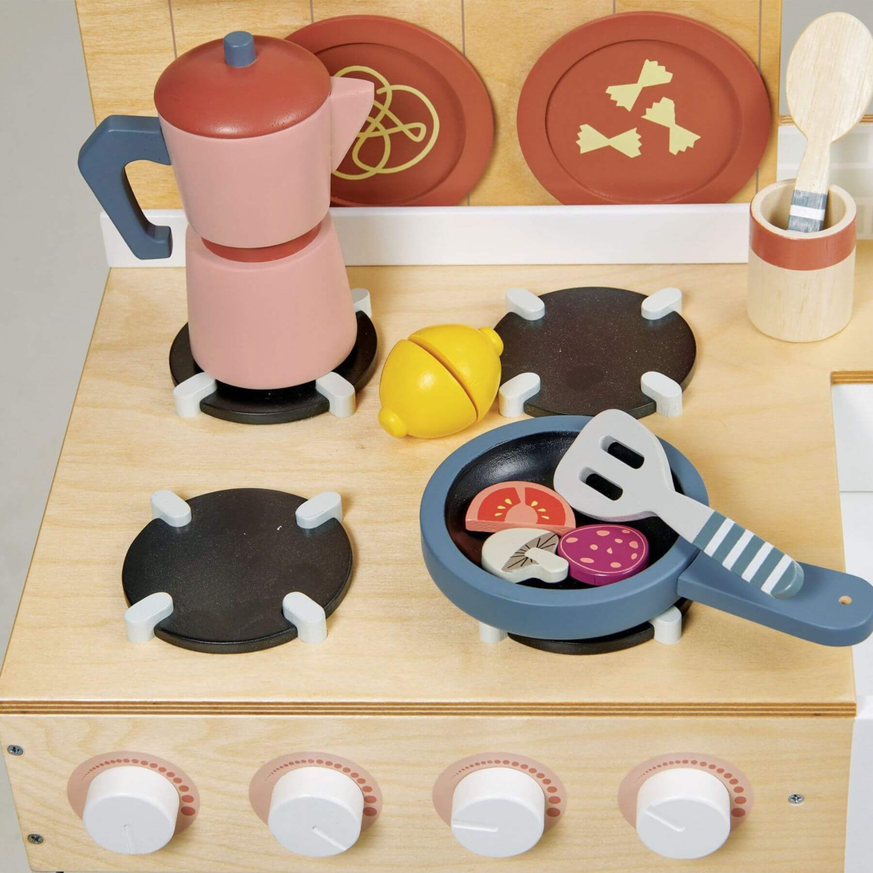 Wooden toy kitchen set with stove, pots, and utensils on a light background