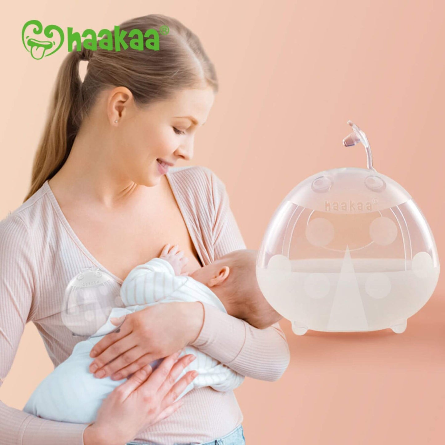 Woman holding a baby with Haakaa Ladybug Silicone Milk Collector
