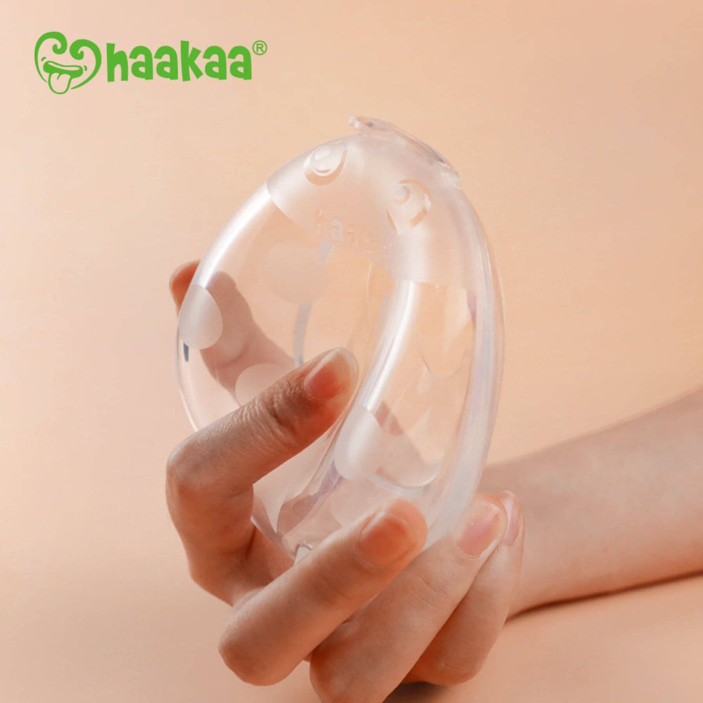 Hand holding Haakaa Ladybug Silicone Milk Collector