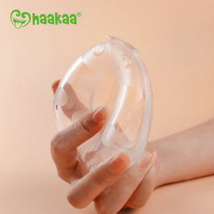Hand holding Haakaa Ladybug Silicone Milk Collector
