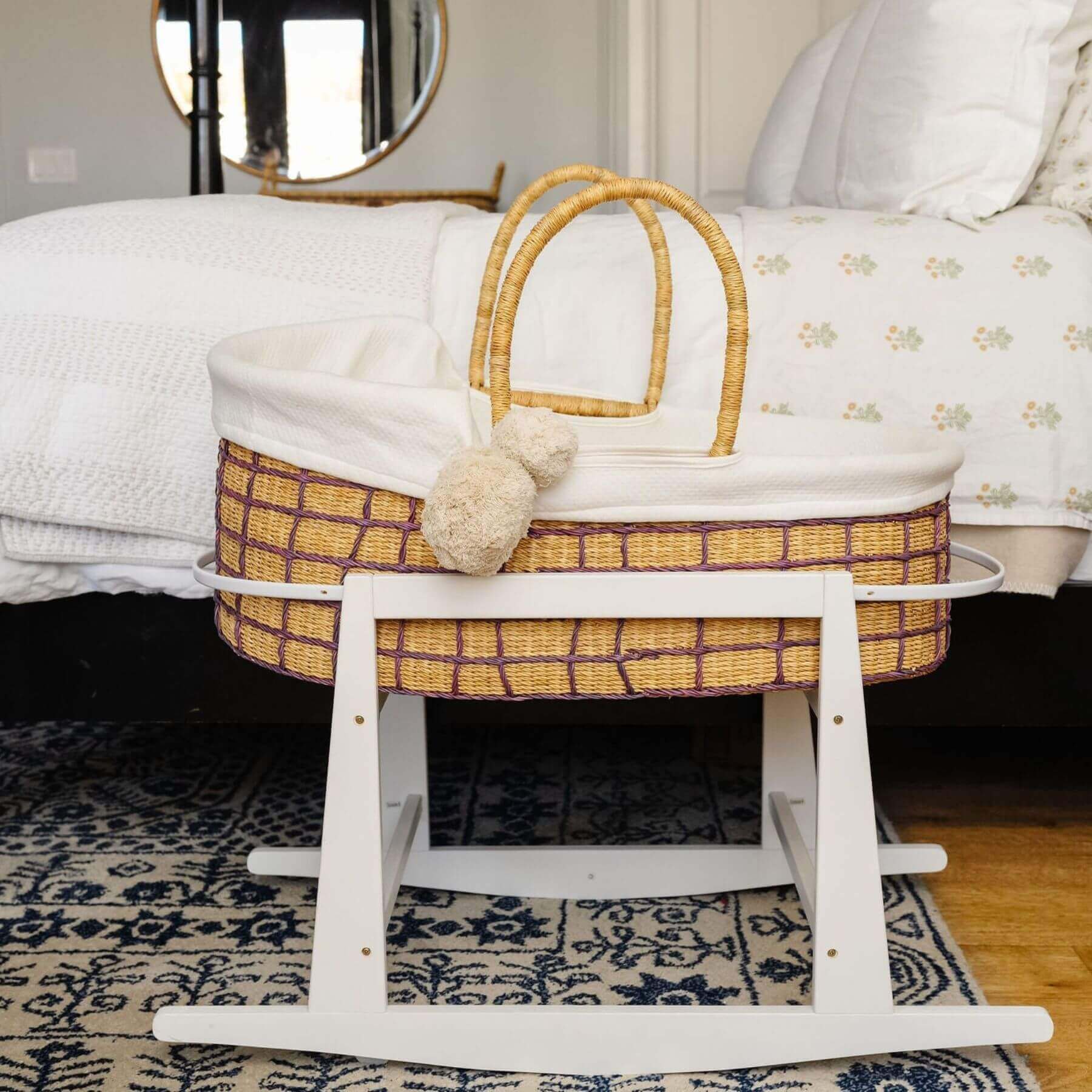 Lavender Grid African Moses Basket Vegan Handle with white bedding on a stand in a bedroom setting.