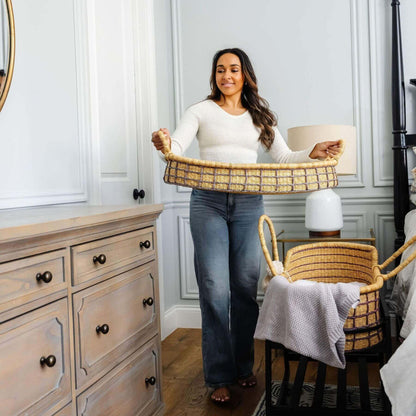 Woman holding Lavender Grid African Moses Basket Vegan Handle in a bedroom setting