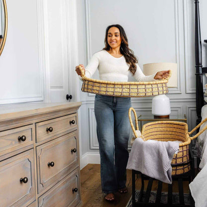 Woman holding a woven basket in a bedroom setting