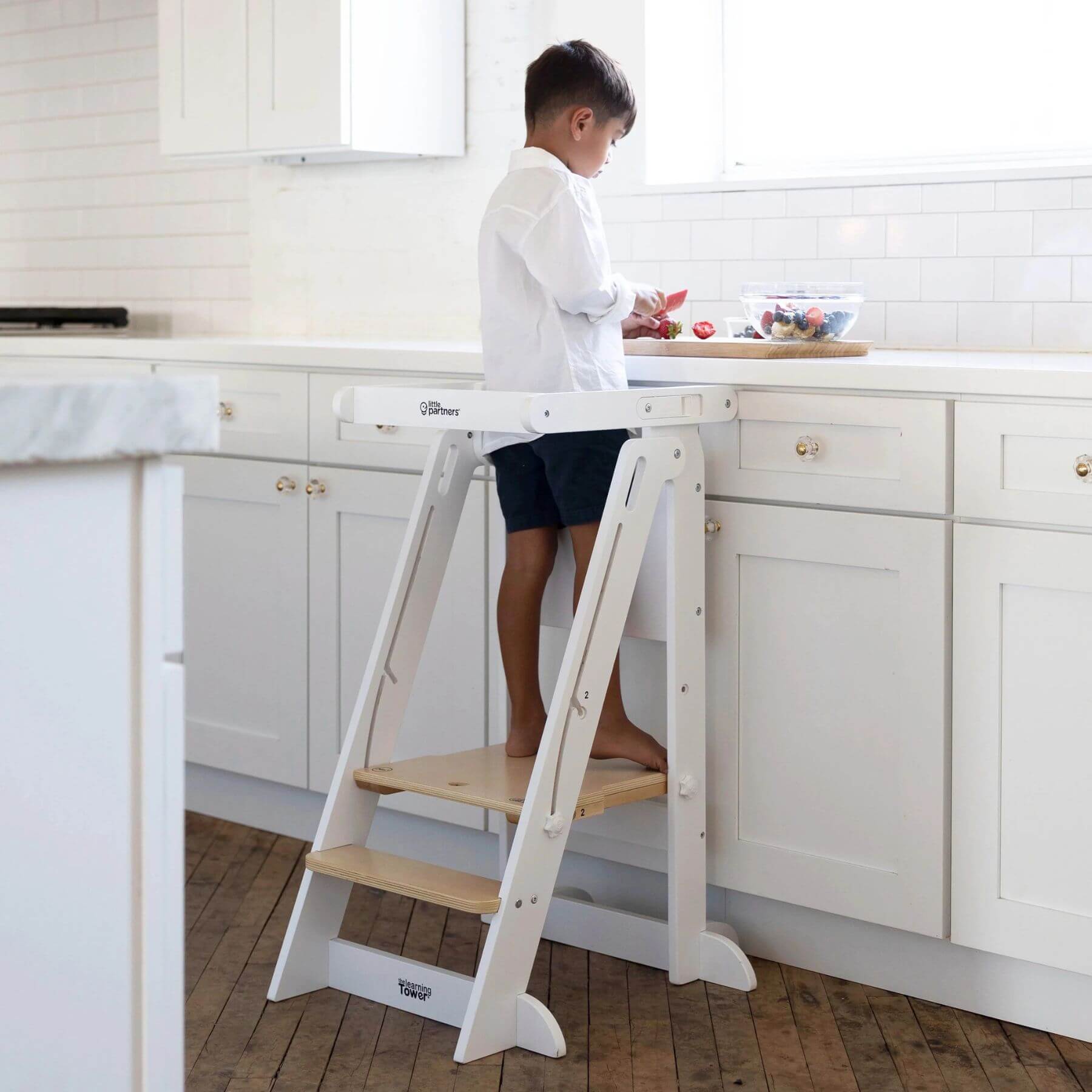Boy Standing on Little Partners Learn 'N Fold Learning Tower Natural & White