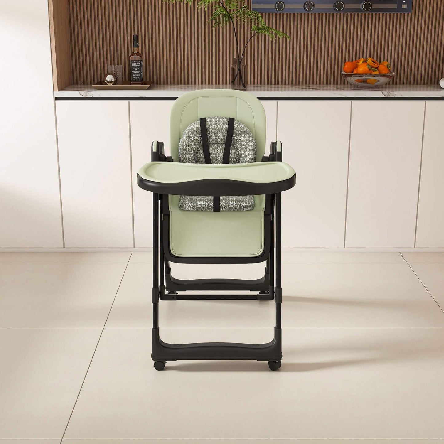 Leavader Adjustable Baby High Chair - Dark Green in a kitchen setting with cabinets and a countertop in the background.
