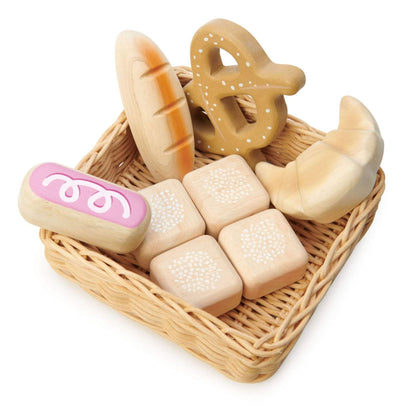 Wooden toy bread set in a wicker basket on a white background