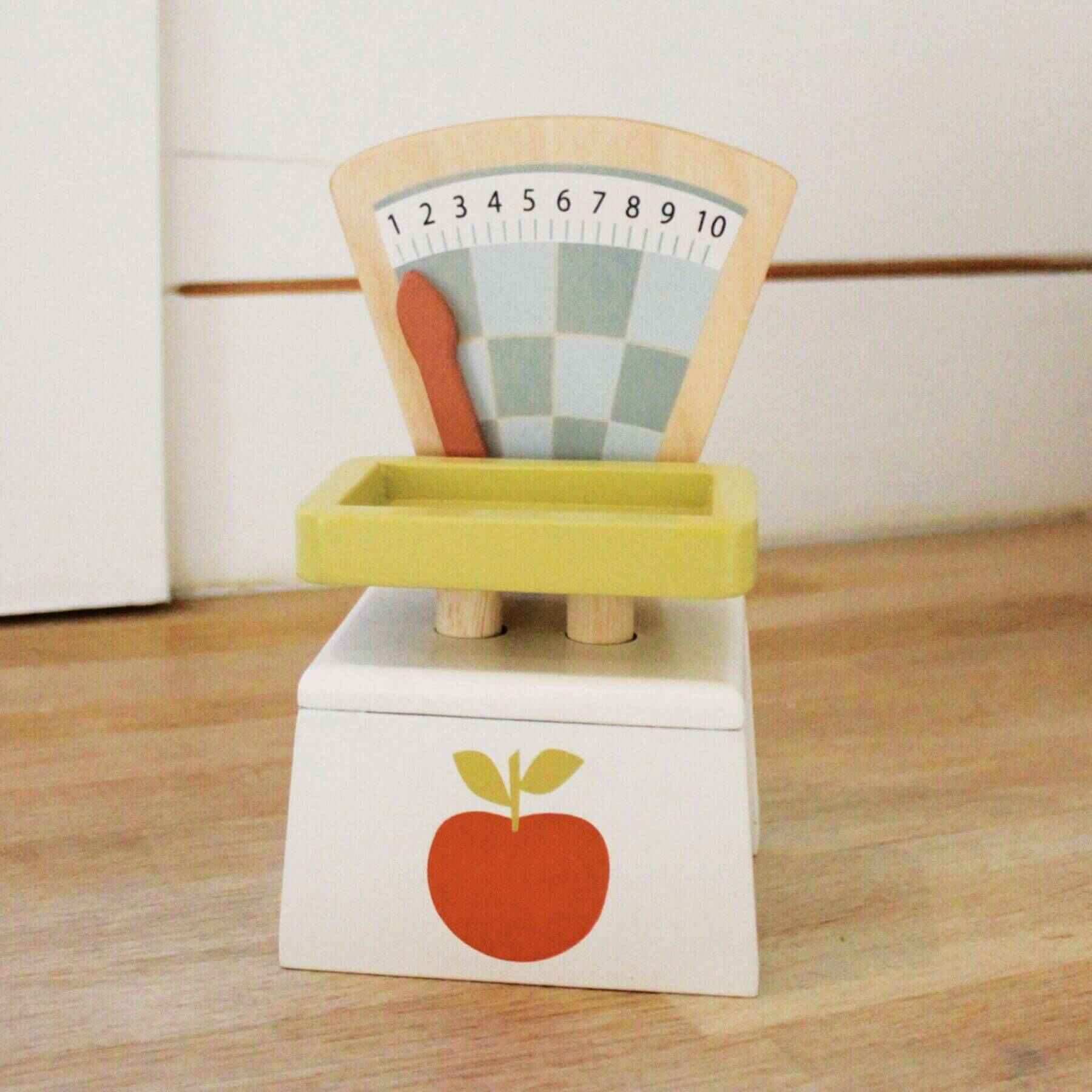 Wooden toy scale with colorful design on a wooden surface