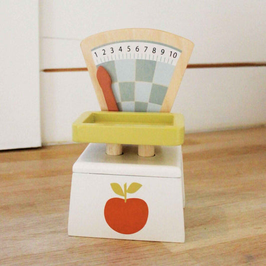 Wooden toy scale with colorful design on a wooden surface