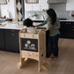 Girl Standing on Little Partners Limited Edition Learning Tower Natural, Helping Mom Cooking
