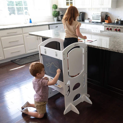 Girl Standing on Little Partners Limited Edition Learning Tower White, with a Boy Drawing on the Blackboard