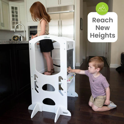 Girl Standing on Little Partners Limited Edition Learning Tower White, with a Boy Drawing on the Blackboard