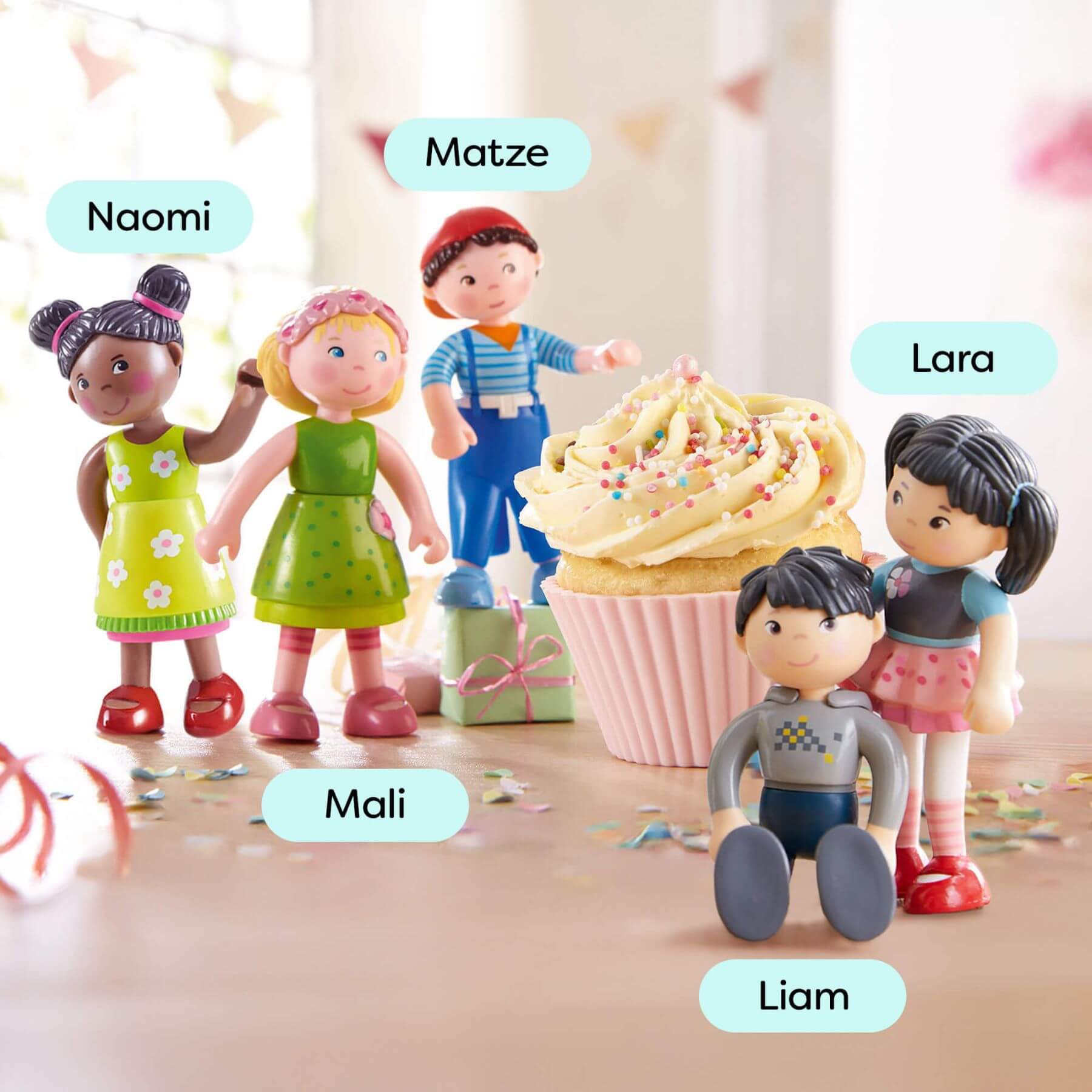 Toy figures of children around a large cupcake with names above each figure.