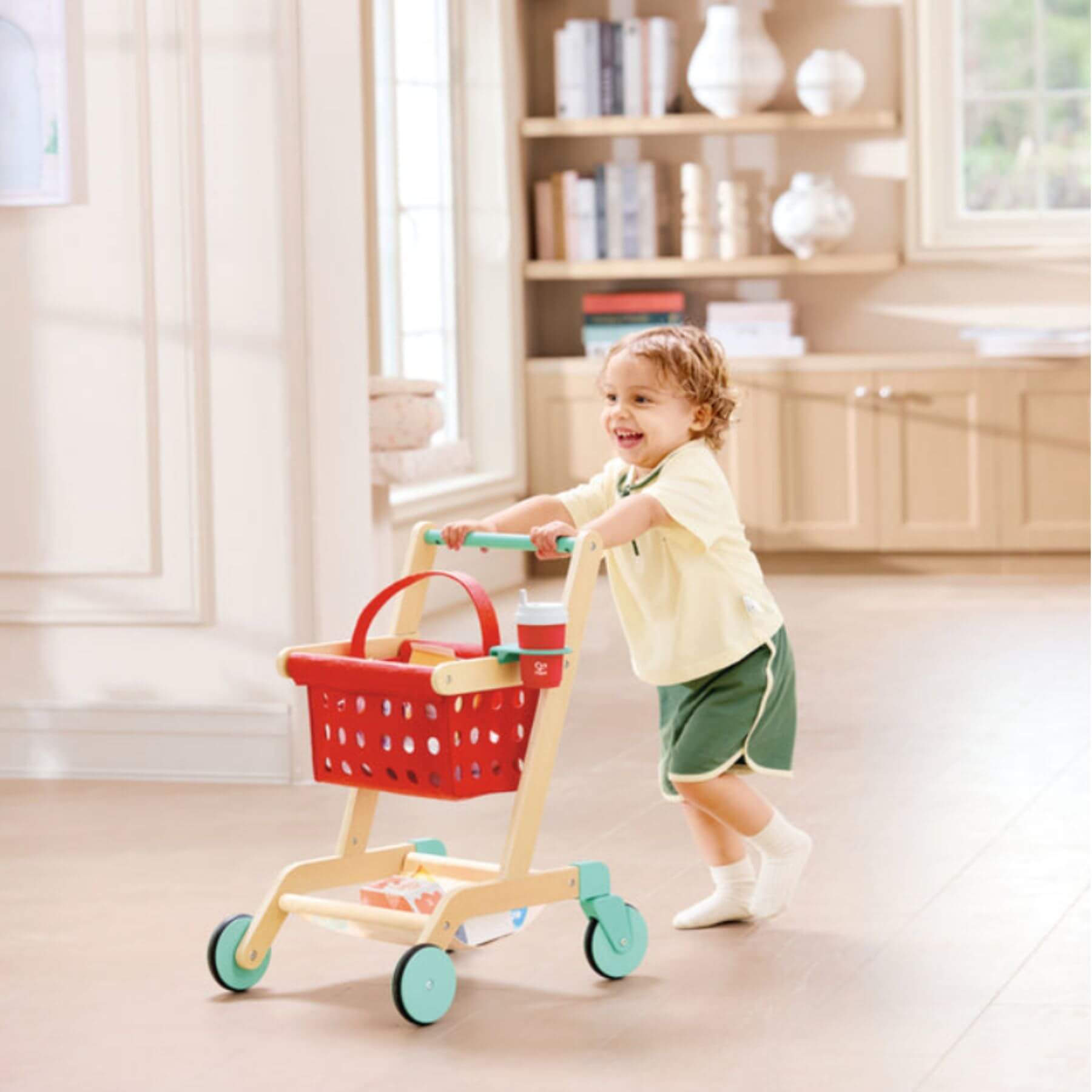 Child playing with Hape Little Shopper's Cart & Basket in a home setting