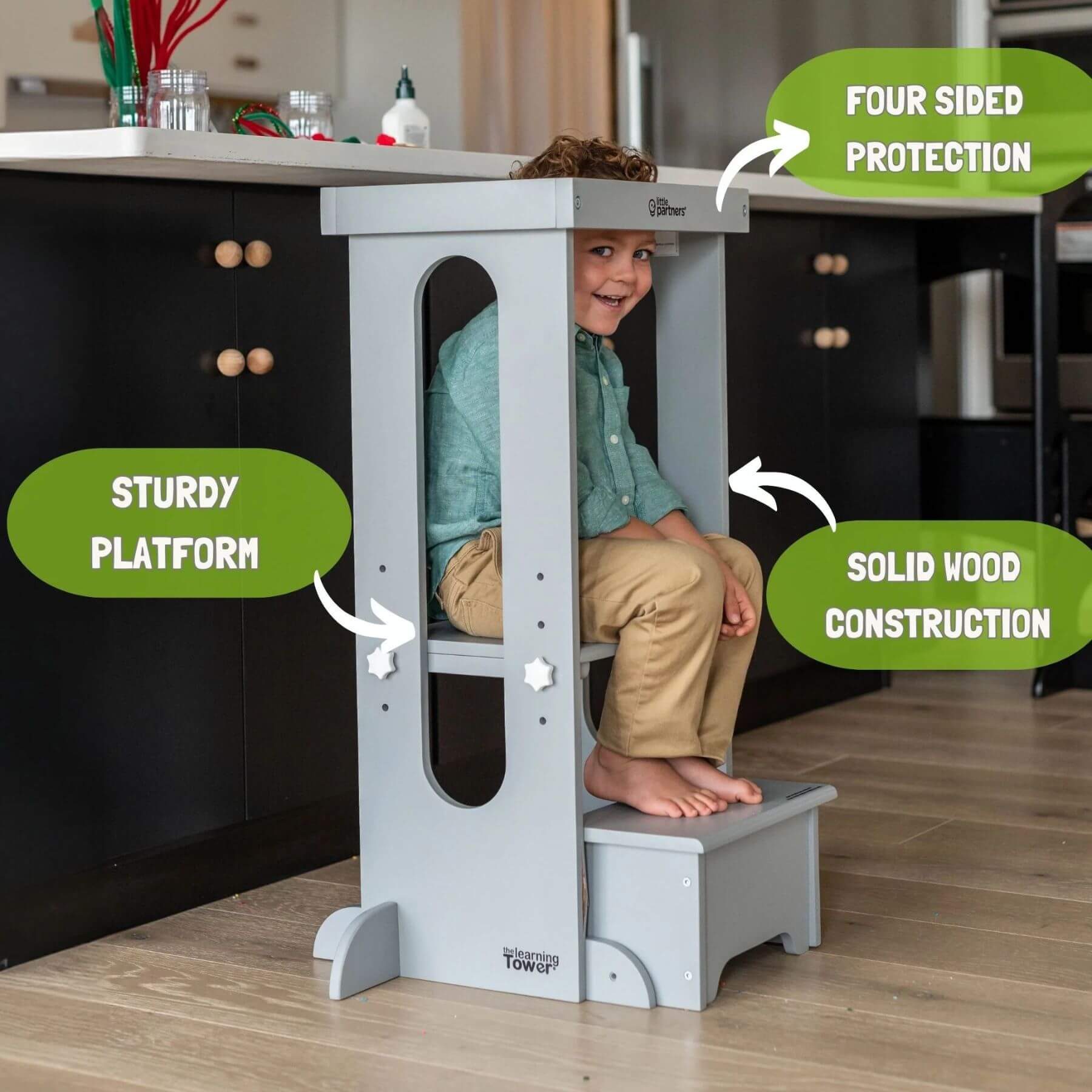 Boy Sitting on the platform of Little Partners Explore 'N Store Learning Tower Silver
