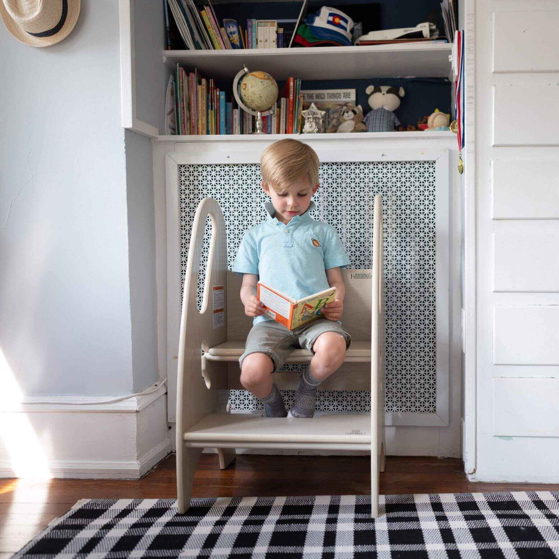 Boy Reading, Sitting on Little Partners 3-in-1 Growing Step Stool Ivory