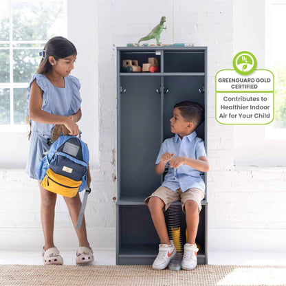 Two children interacting with Little Partners Learn 'N Store Cubby Grey in a room with a white brick wall.