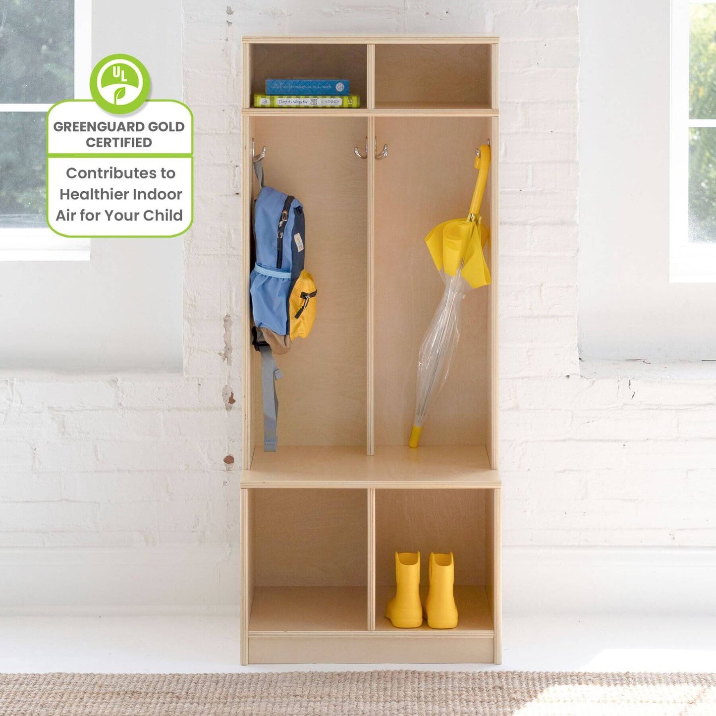 Little Partners Learn 'N Store Cubby Natural with children's items against a white brick wall, featuring a GreenGuard Gold certification label.