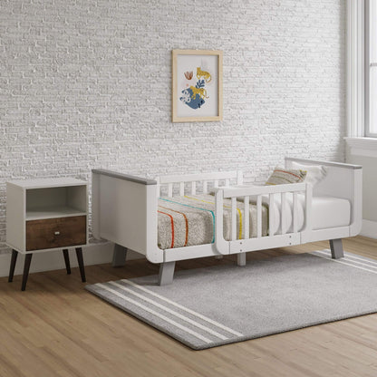 Children's room with a Little Partners MOD Toddler Bed Grey & White, nightstand, and framed artwork on a brick-patterned wall.