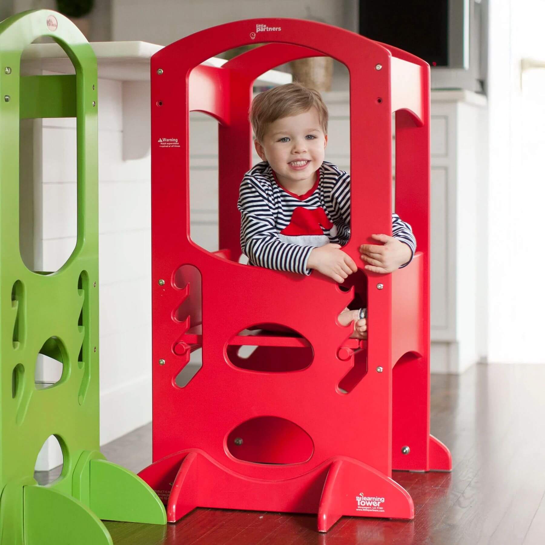 Boy Sitting on the platform of Little Partners The Learning Tower Red