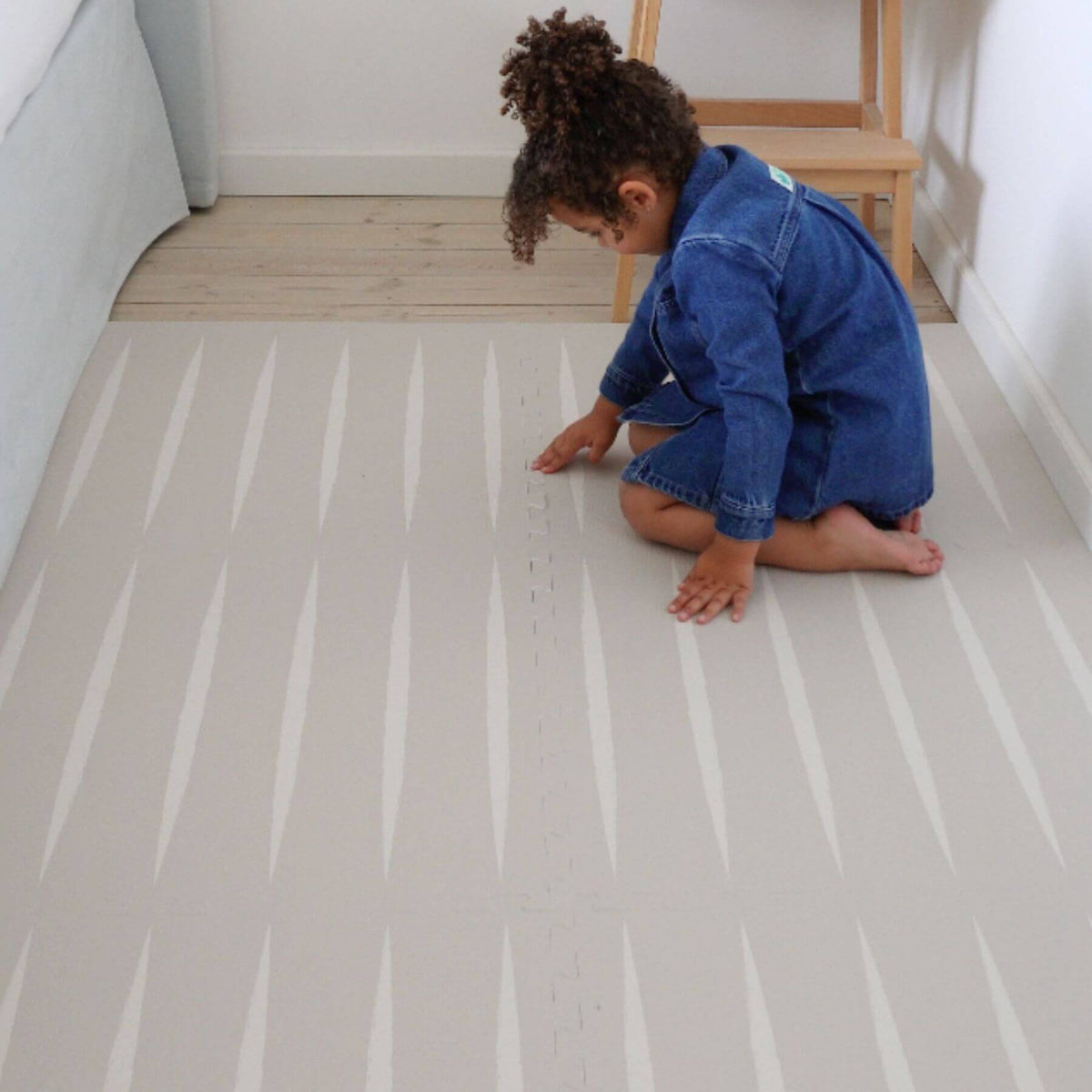 Child playing on Eeveve Lucio Play Mat - Linen