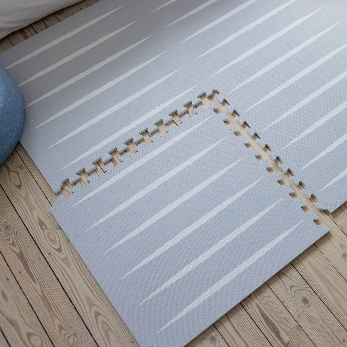 Lucio Play Mat Nordic Mist on a wooden floor