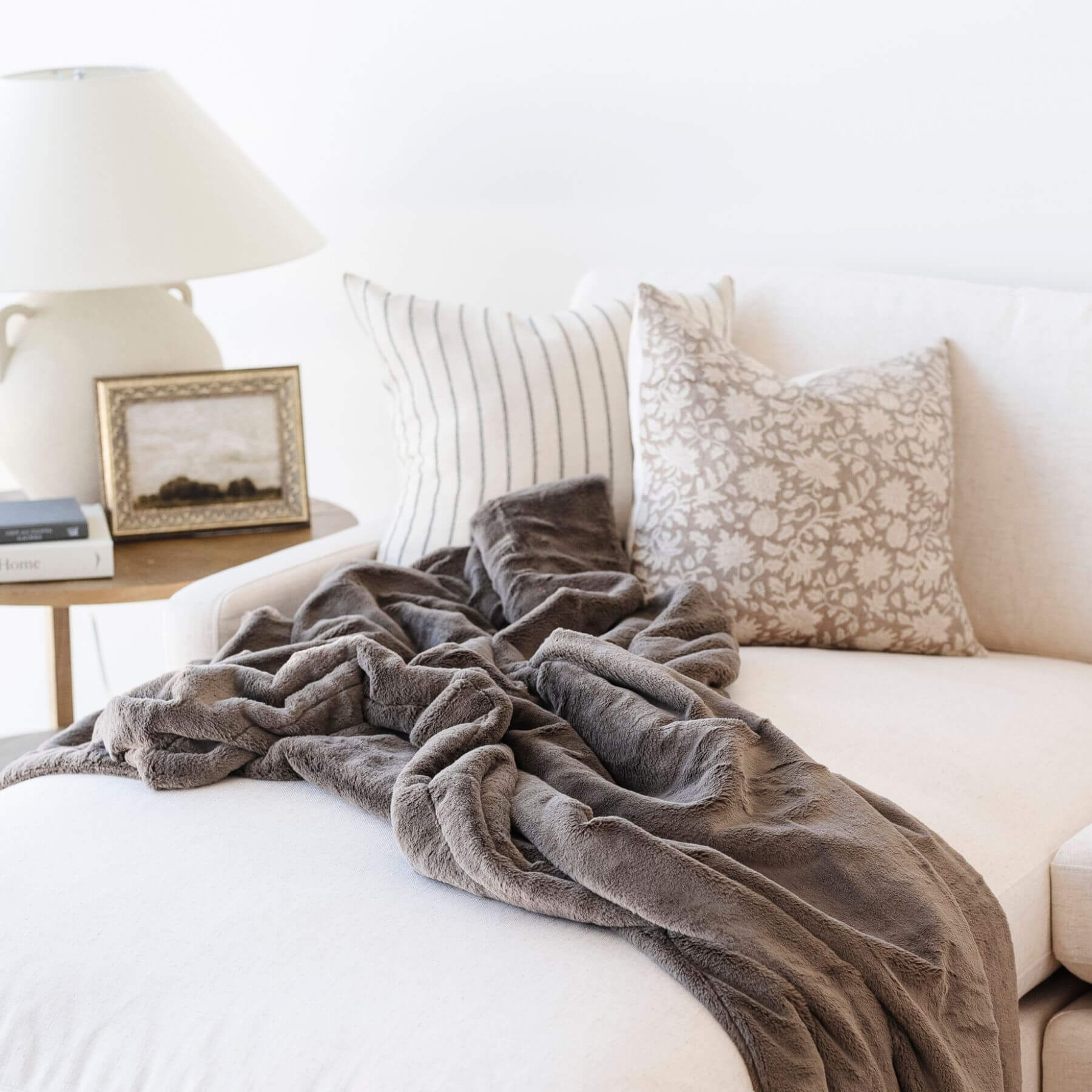 Saranoni Lush Throw Blanket Walnut draped over a white sofa with decorative pillows in a cozy living room setting.