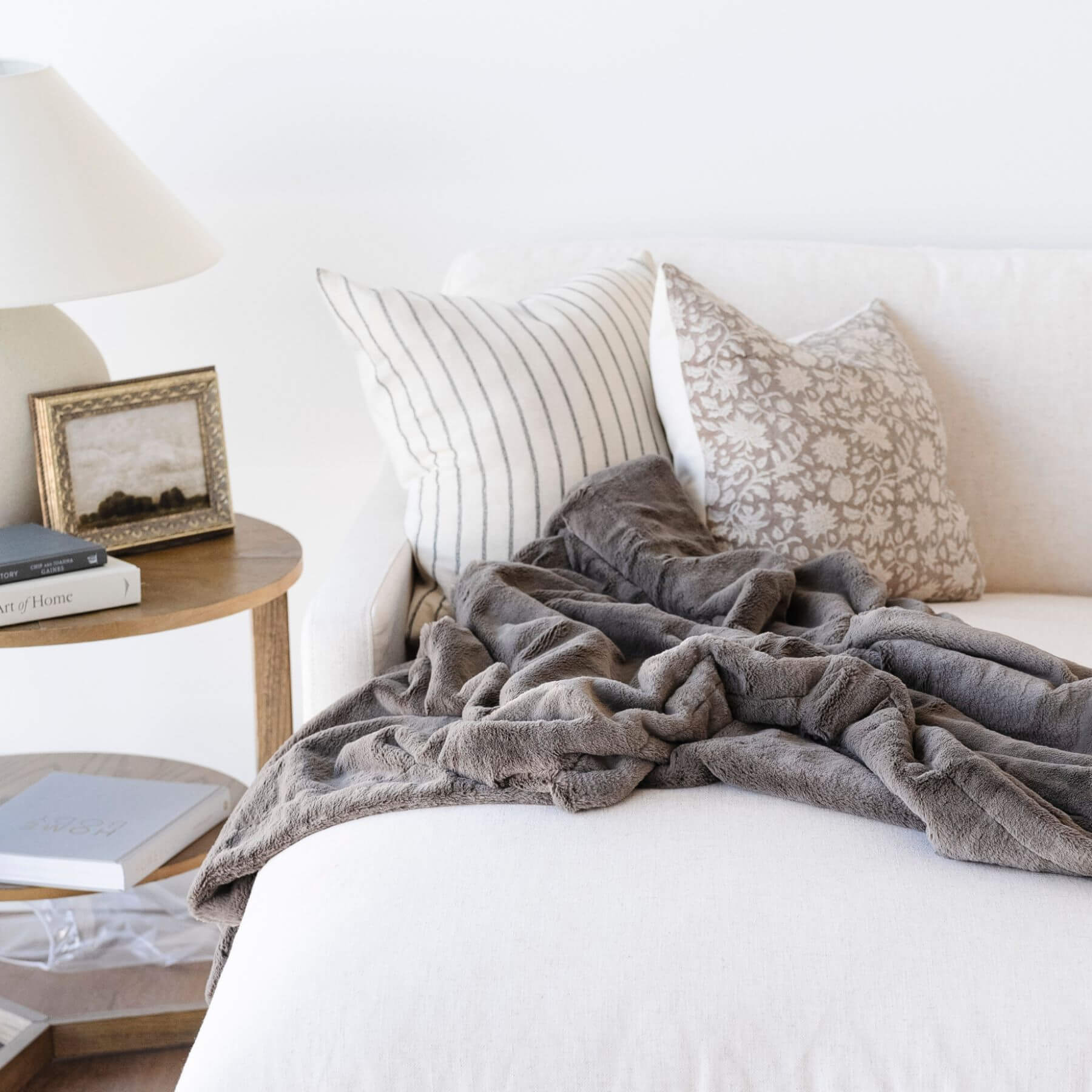 Saranoni Lush Throw Blanket Walnut draped over a white sofa with decorative pillows and a side table in the background.