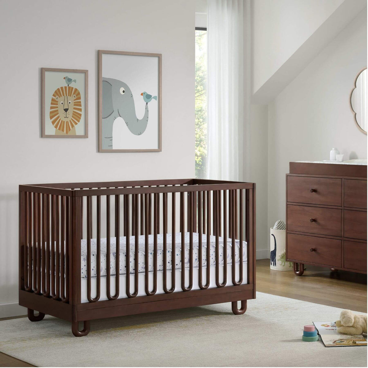 Soho Baby Meridian Island Crib - Cognac in a nursery with a dresser and wall art.