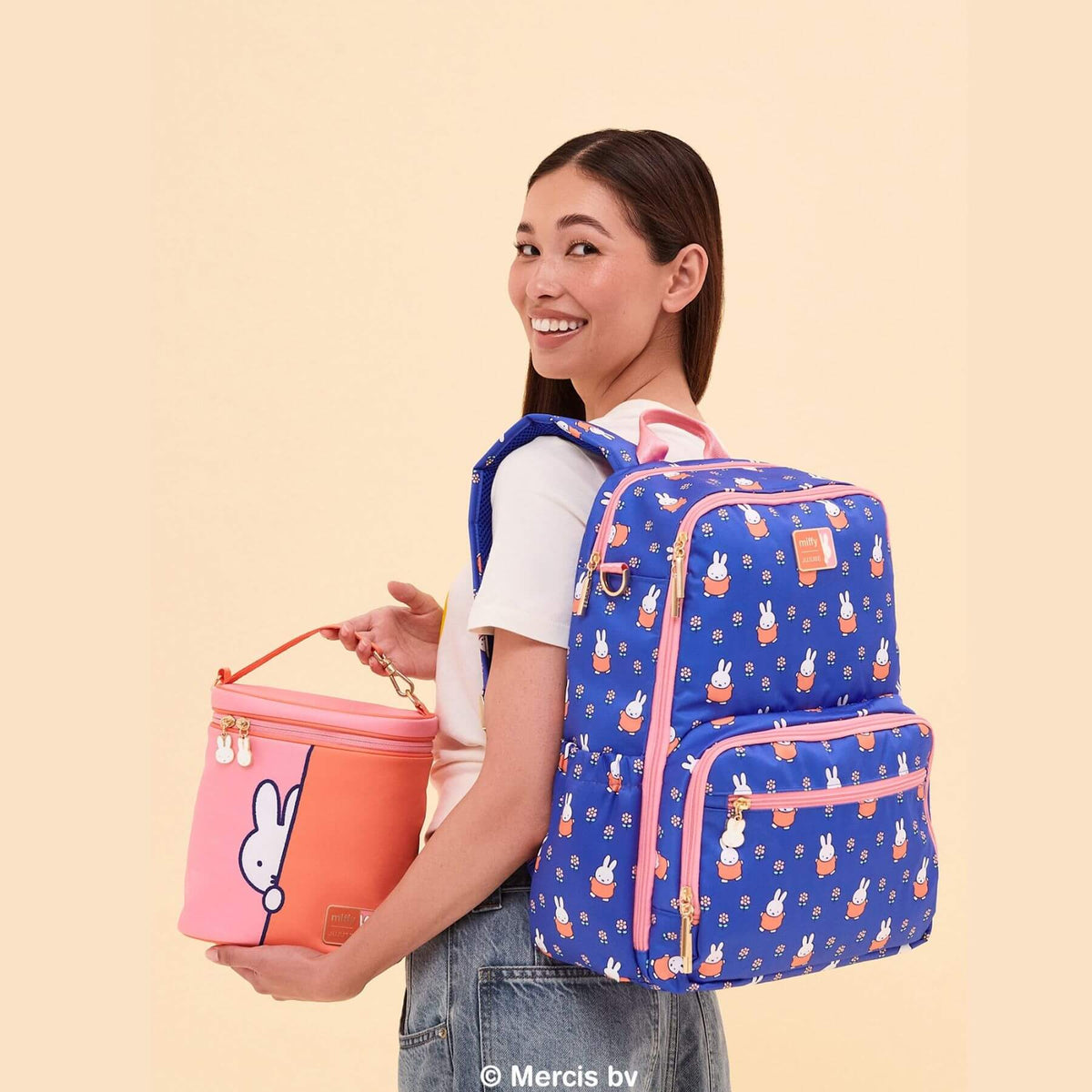 Woman wearing Miffy Flower Fields Zealous Diaper Bag Backpack - Blue & Orange