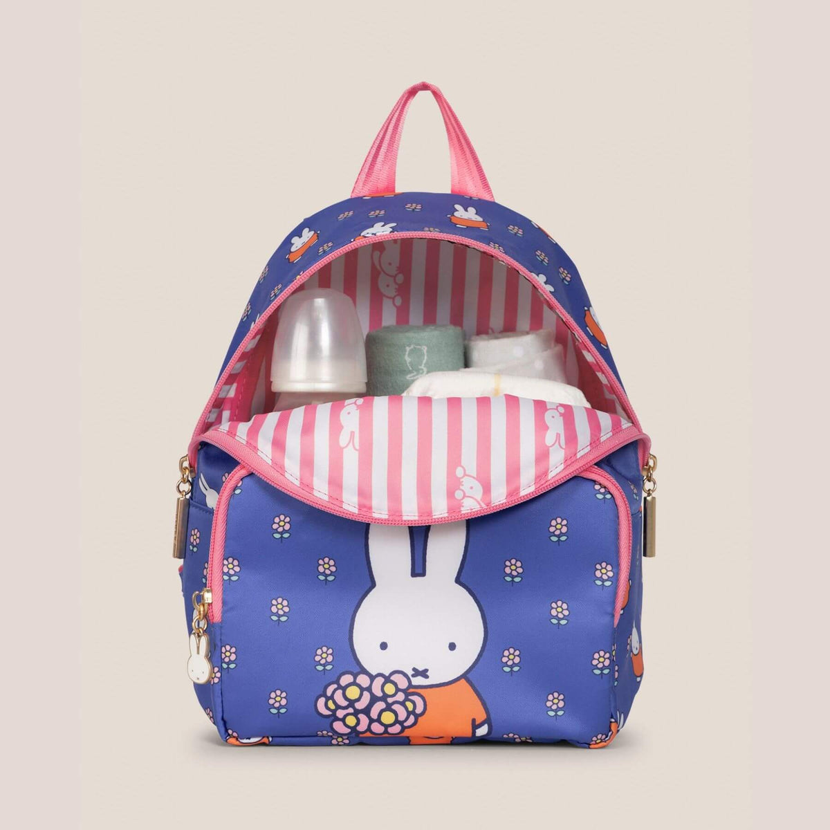 Miffy Flower Fields Everyday Mini Backpack - Blue & Orange. The bag is shown open, revealing a striped interior lining and baby accessories stored inside, set against a solid beige background.