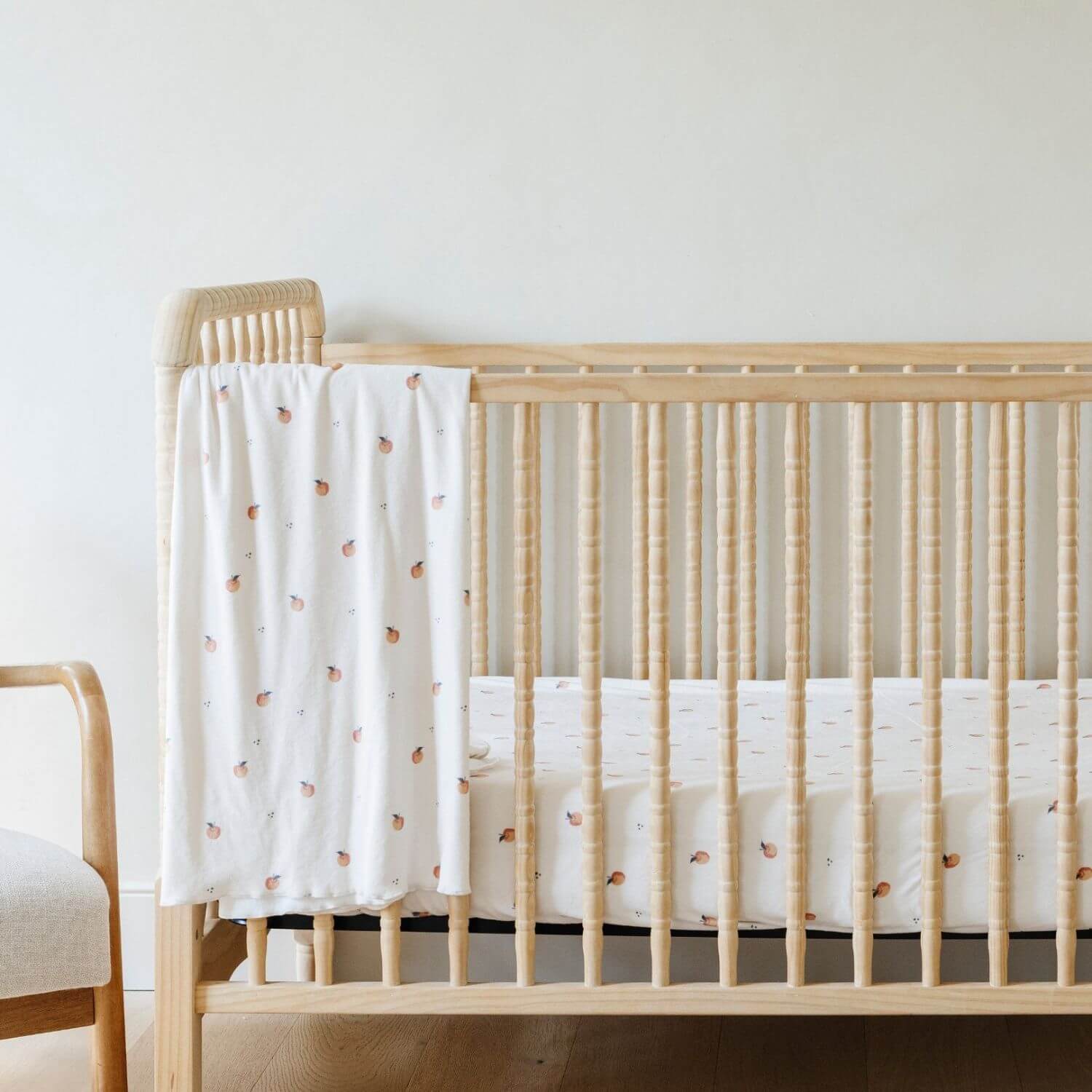 Saranoni Minky Stretch Luxe Crib Sheet Apple hanging on wooden crib