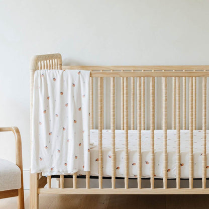 Saranoni Minky Stretch Luxe Crib Sheet Apple hanging on wooden crib
