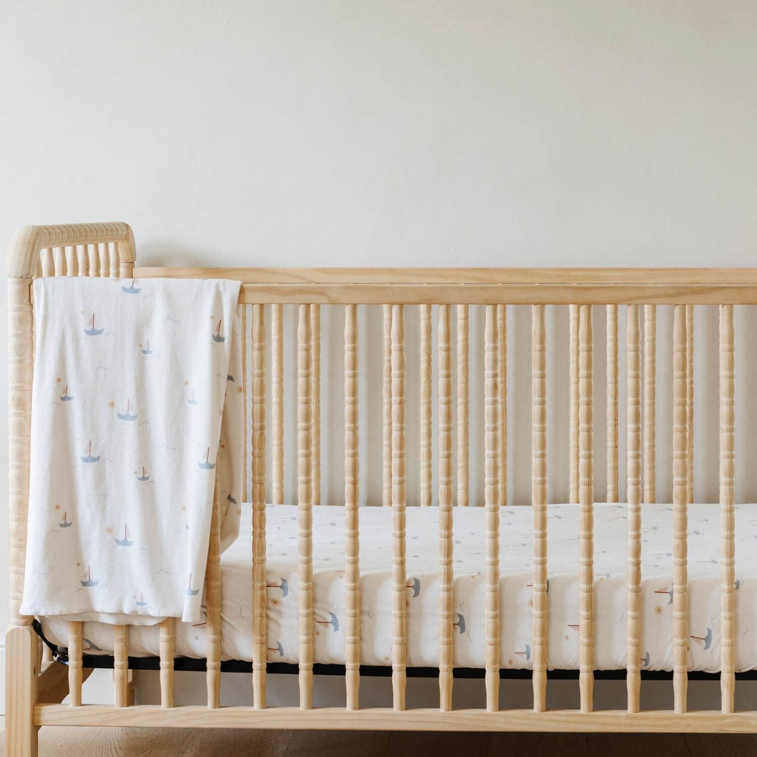 Saranoni Minky Stretch Luxe Crib Sheet Sail Boat hanging on wooden crib