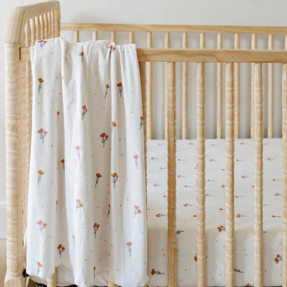 Saranoni Minky Stretch Luxe Crib Sheet Coral hanging on wooden crib