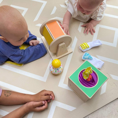 Two babies playing with colorful toys on Eeveve Modern Blocks Play Mat - Beige
