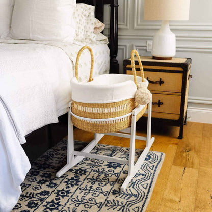 Modern Open Weave African Moses Basket Vegan Handle on a stand in a bedroom setting with a bed and nightstand.