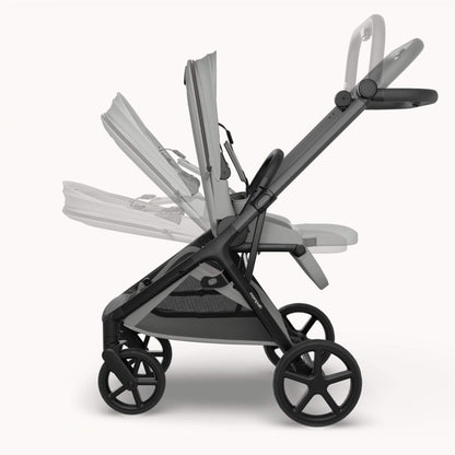 Mompush Vira stroller - Gray shown in side profile on a clean light gray studio background, with a faded secondary view of the seat/cushion configuration behind it to demonstrate flexibility.