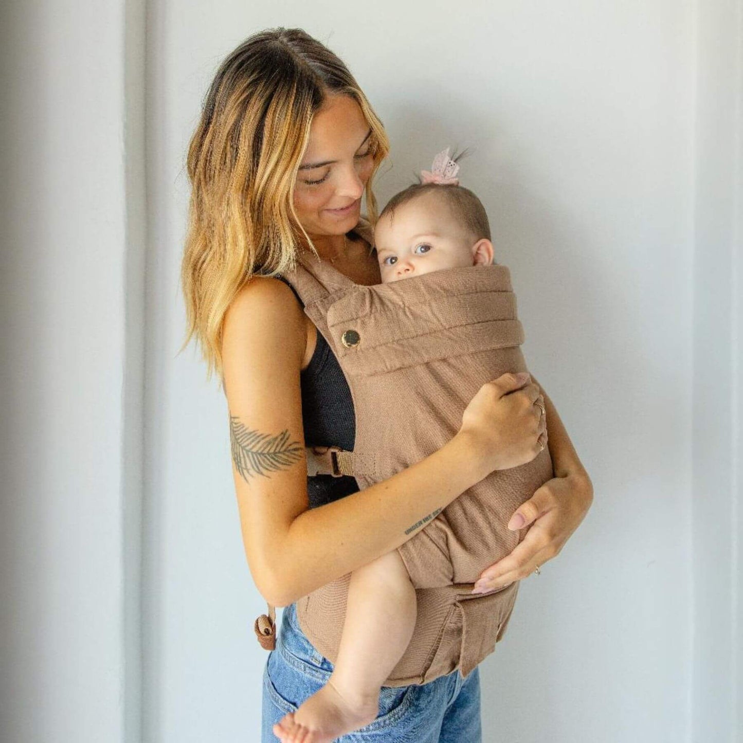 Woman holding a baby in Monroe x Coco Desert - Cotton Linen Baby Carrier