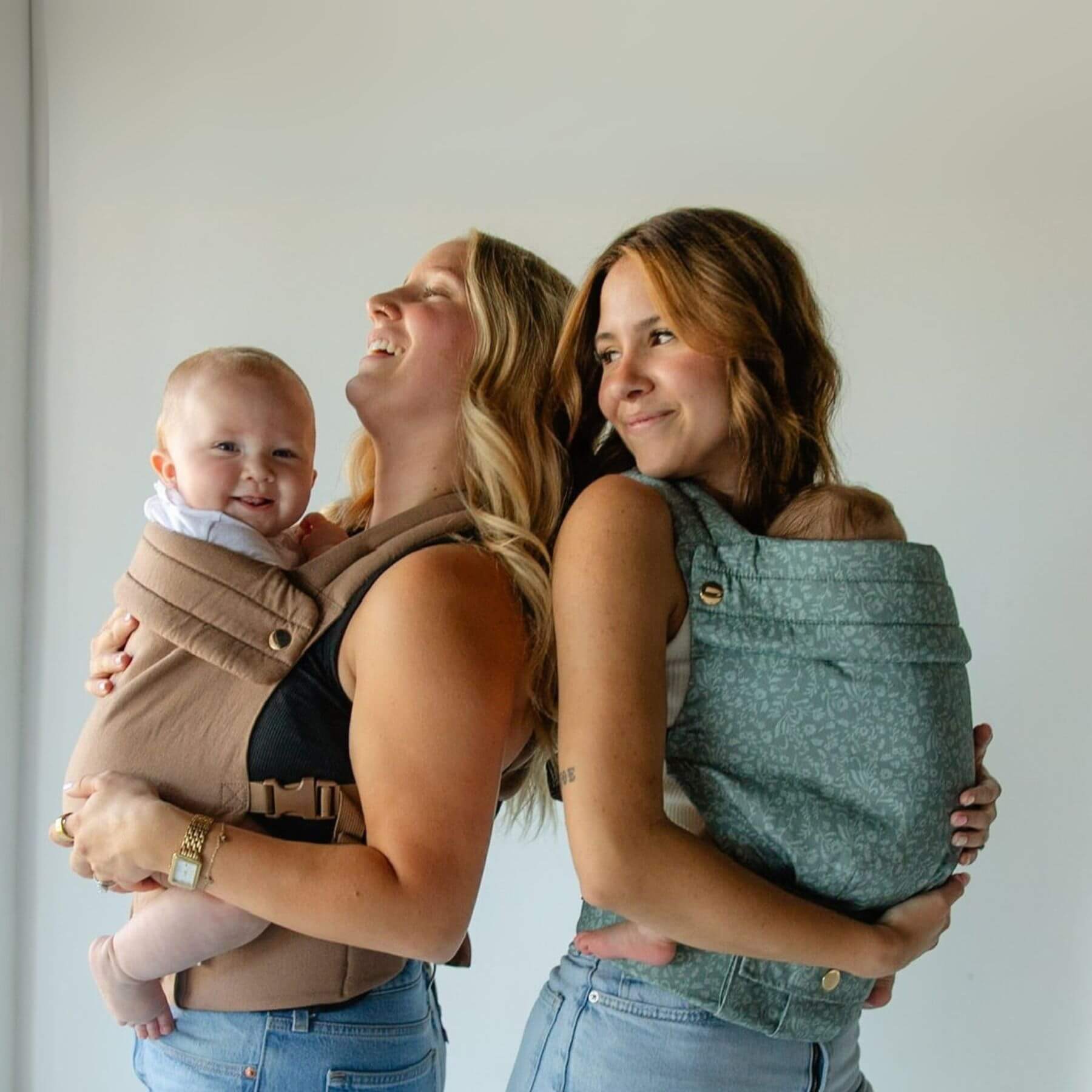 Two women carrying babies in Monroe x Coco Bloom – Neutral Cotton Baby Carrier