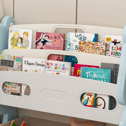Children's books in a white bookshelf against a beige wall.