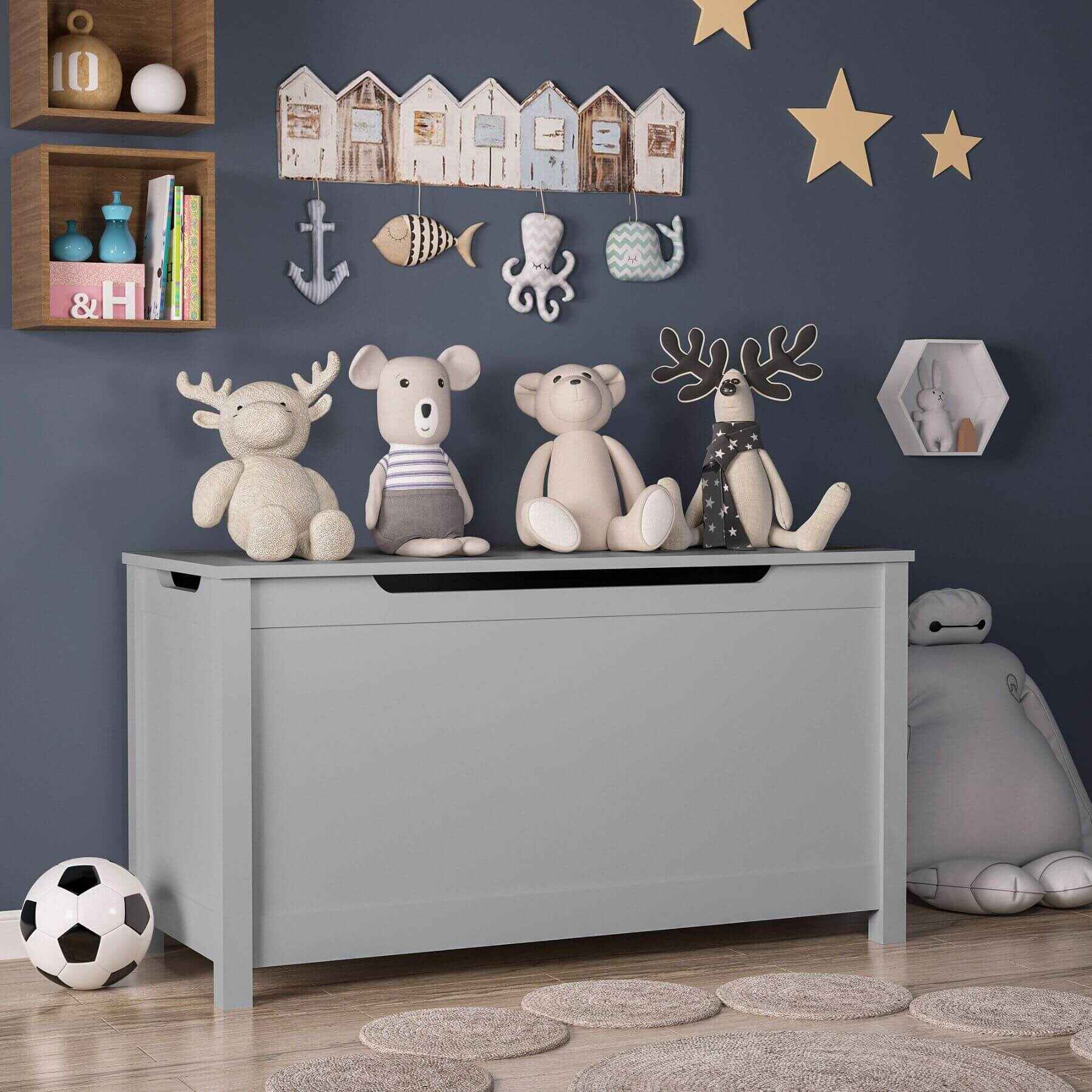 MOONRIVER Kids Wooden Toy Box Storage with Safety Hinged Lid - Grey with stuffed animals against a wall decorated with star and house decorations.