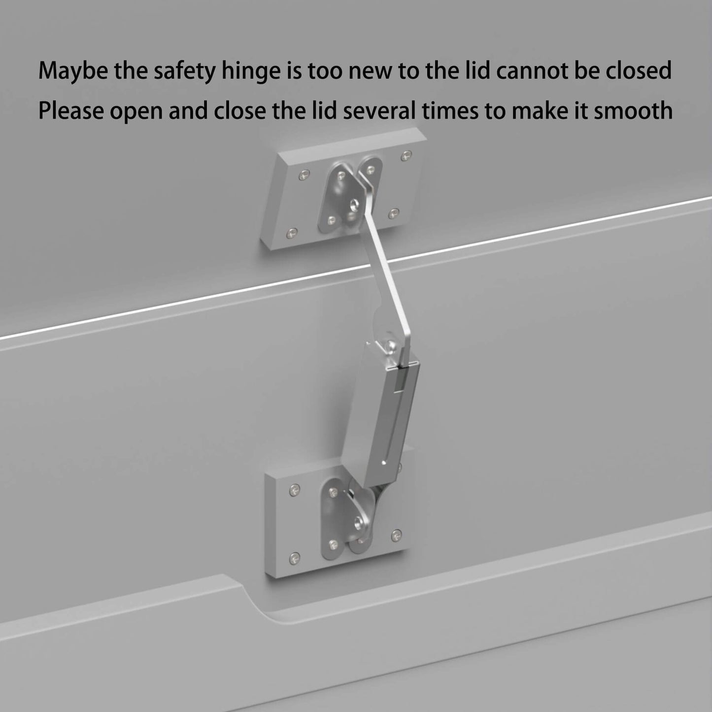 Metal safety hinge on a gray surface with text advising to open and close the lid.