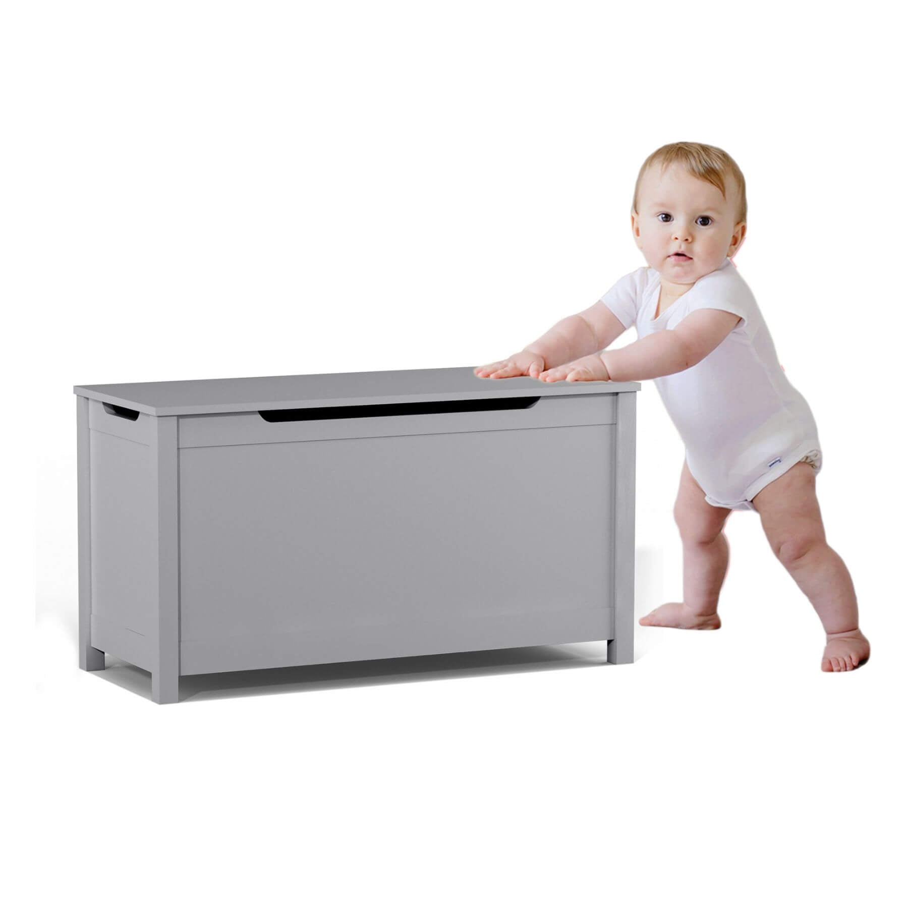 Baby in a white onesie standing next to MOONRIVER Kids Wooden Toy Box Storage with Safety Hinged Lid - Grey