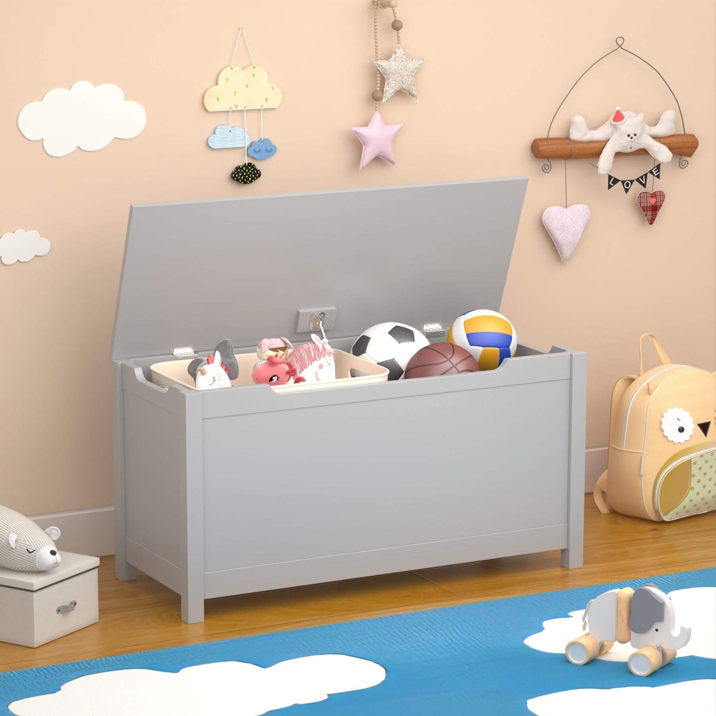 MOONRIVER Kids Wooden Toy Box Storage with Safety Hinged Lid - Grey with various toys inside, placed on a wooden floor with decorative wall items.